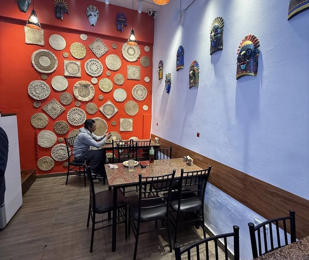 Decoración del local con pared roja y platos artesanales
